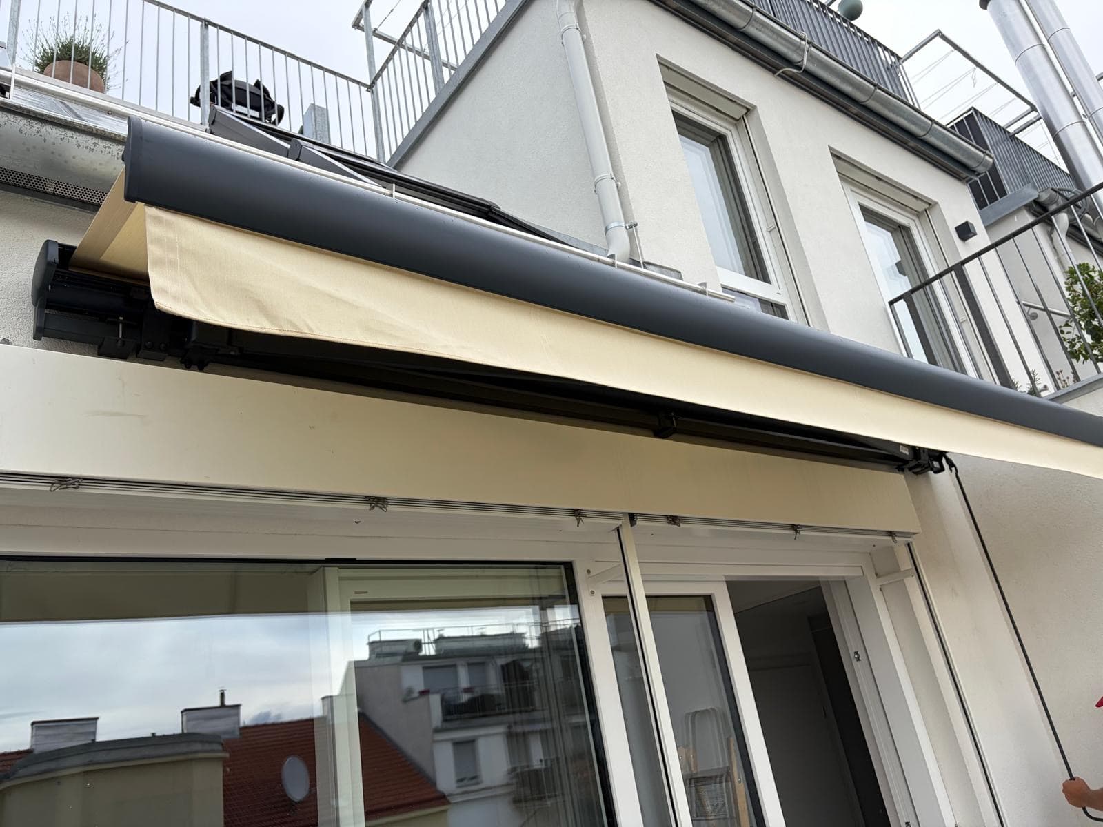 Halbkassettenmarkise in Creme mit anthrazitfarbener Kassette auf einer Terrasse von AF Fliegengitter