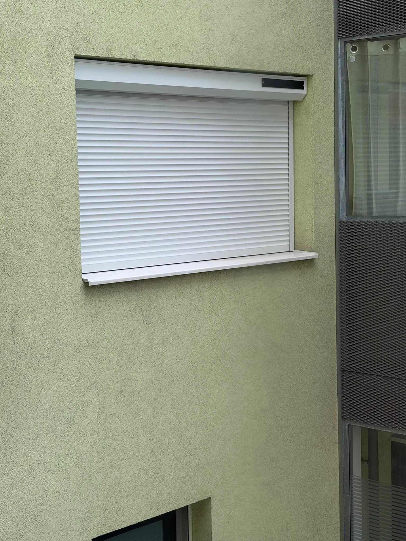 Fertig montierter weißer Außenrollladen an einer Wohnung im 22. Wiener Gemeindebezirk
